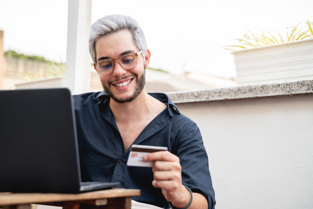 young-hipster-man-holding-credit-cart-using-comput-2022-01-18-23-34-37-utc-scaled.jpg